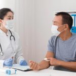 A doctor checking a patient. Both are in surgical mask.