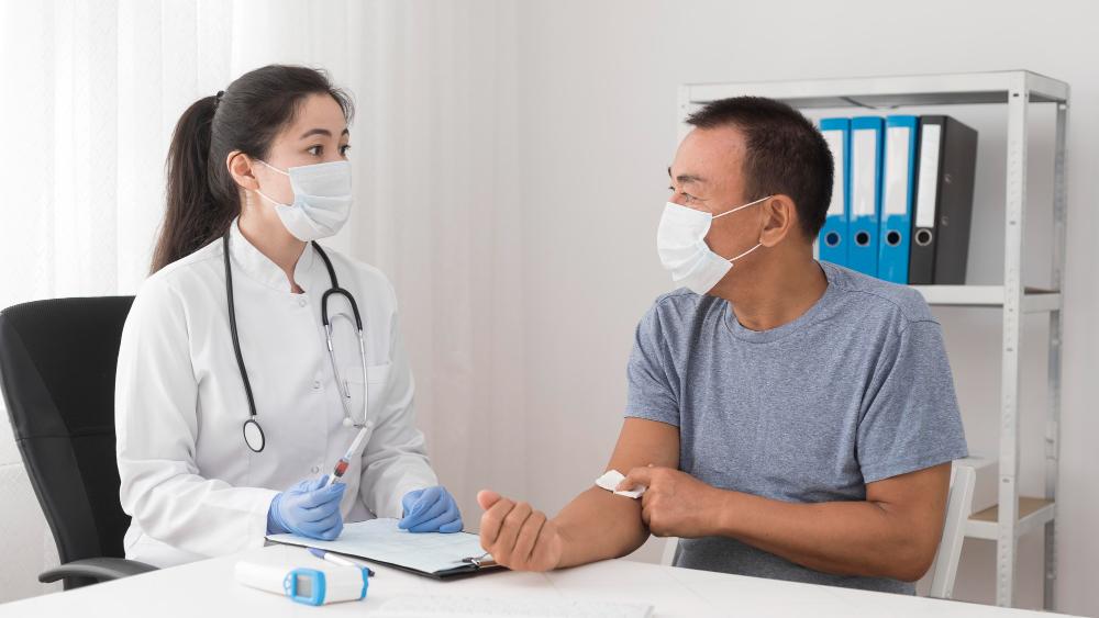 A doctor checking a patient. Both are in surgical mask.